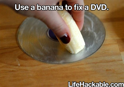 Image: Someone rubbing a cut banana onto the silver side of a DVD. Image text: Use a banana to fix a DVD.